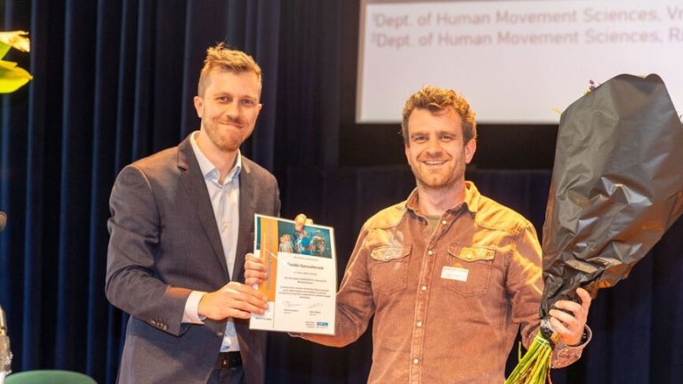 Guido Geusebroek is congratulated by the jury chair Kaj Emanuel, for winning the AMS Outstanding Paper Award 2024, in the Basic Science category., 