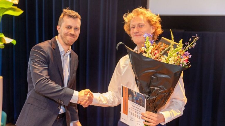 Raven Huiberts is congratulated by the jury chair Kaj Emanuel, for winning the AMS Outstanding Paper Award 2024, in the category Sports & Health.
