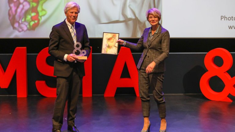 Hergen Spits ontvangt zijn award uit handen van Frida van den Maagdenberg van de Raad van Bestuur van Amsterdam UMC