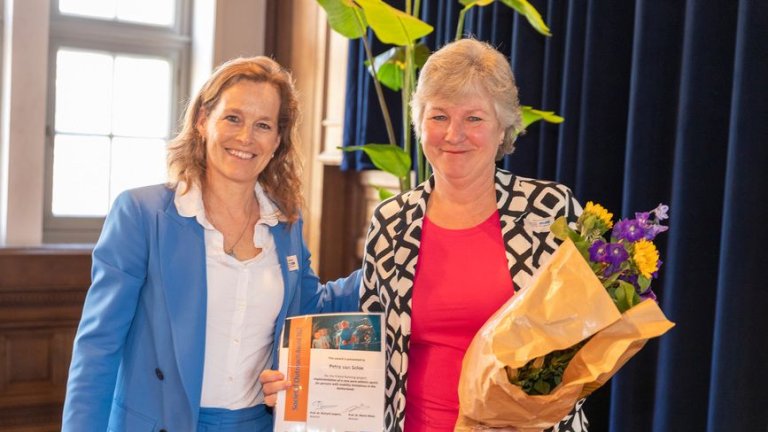 Annieck Timmerman (l) congratulating Petra van Schie on winning the Societal Outreach Award